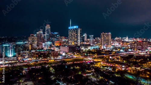 Nighttime hyperlapse of Austin skyline. Drone circles to the right as traffic and skyscrapers light up the city. photo