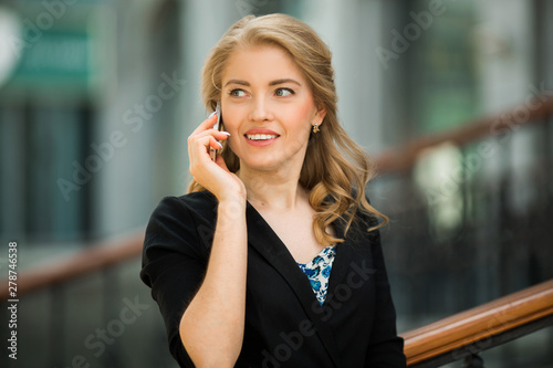 beautiful young woman in a black suit talking on the phone