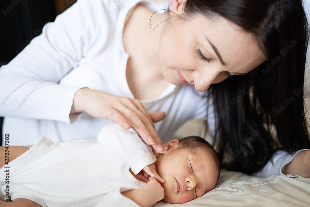 mother lovingly stroking kissing newborn baby mother lovingly stroking kissing newborn baby