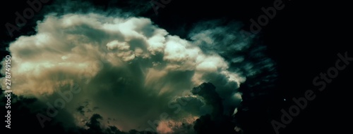 Big dramatic storm cloud (probably cumulonimbus) at summer twylight beside small moon (on the right side) photo