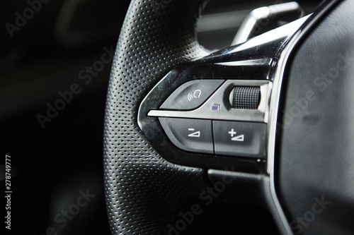 Photo selective focus of steering wheel near gear shift handle in luxury car
