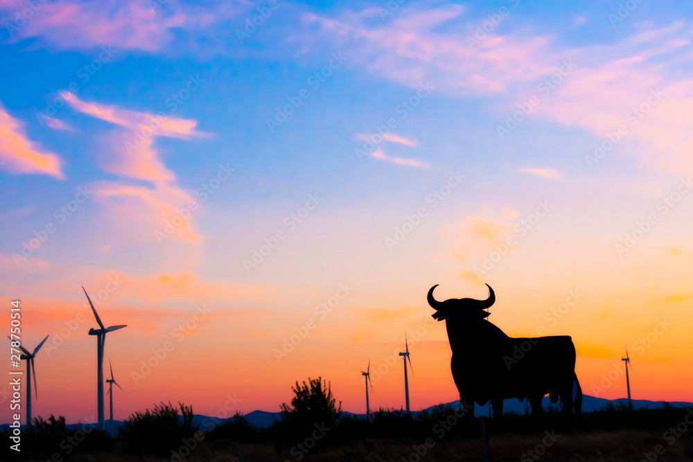 Spanish bull roadsign  in the sunset with the wind generators in background