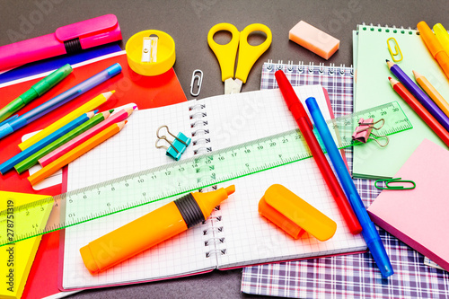 Back to school concept. School education supplies on black stone concrete background.