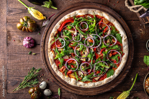 Tasty hot italian pizza Primavera with Broccoli, Arugula, Eggplant, Mushrooms, Red Onions, Tomatoes, Sweet Peppers, Tomato Sauce  on old wooden table. Pizzeria menu. Concept poster for Restaurants