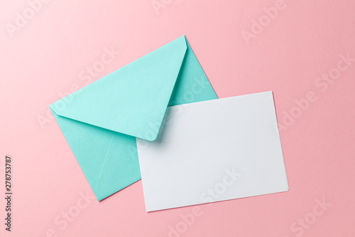 Green envelope and blank letter on pink background. Template with place for text on postcard. mock-up photo