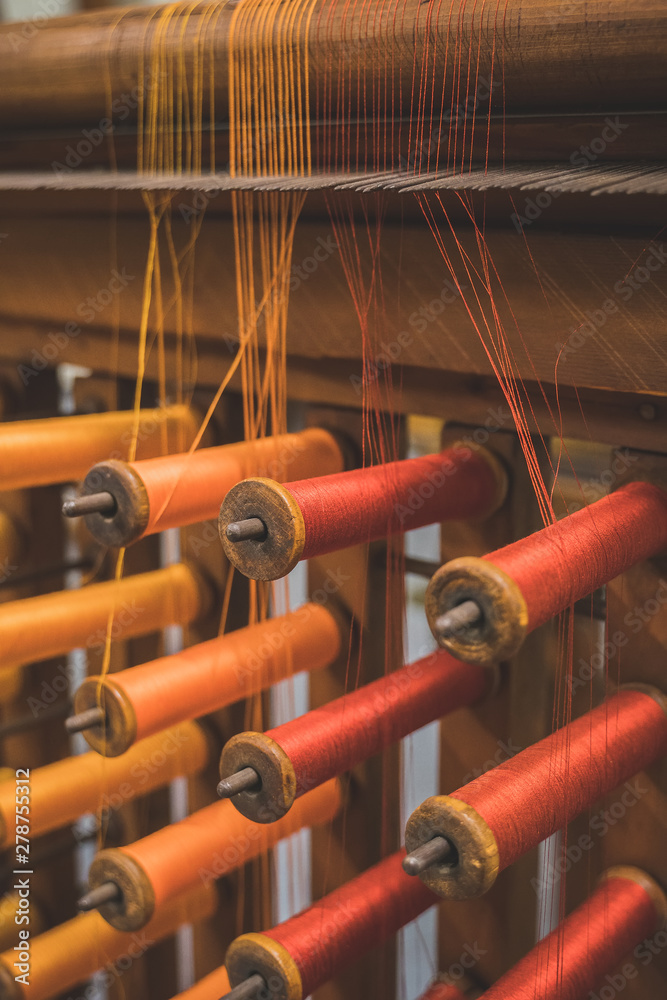 Many multi-colored spool of threads in a sewing factory.