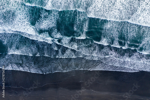 Платно Aerial view of Atlantic ocean waves washing black sandy beach