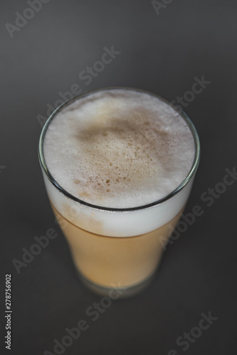 large transparent glass filled with of aromatic coffee photographed on the isolated gray background picture for the menu.