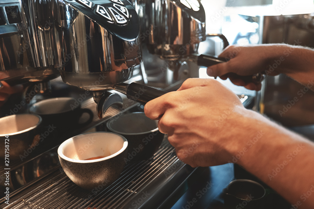 barista man making two cups of coffee drink at the same time using professional coffee machine in cafe