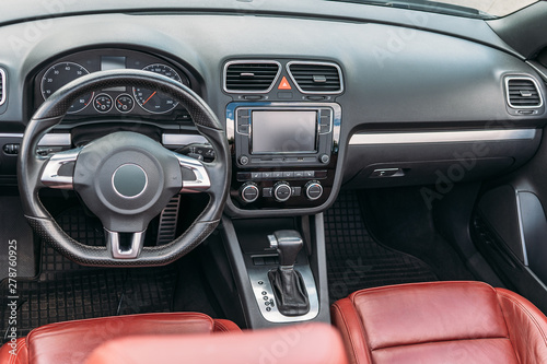 Luxury car interior with dashboard, steering wheel and leather seats