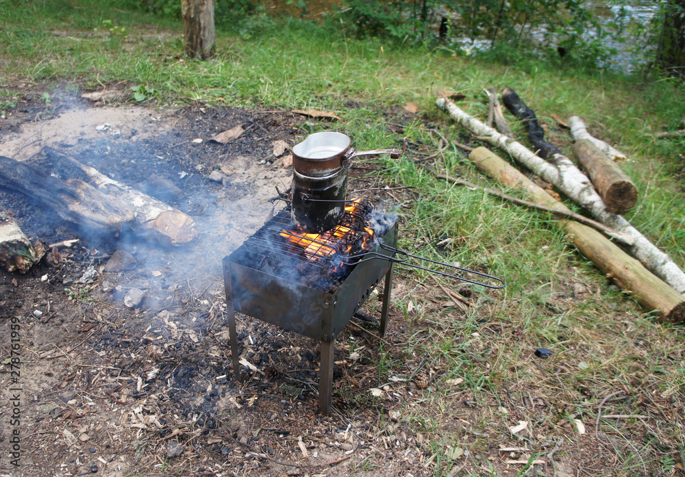 Cooking food on the grill on the coals in the pot at the campsite. Cooking food on the grill on the coals in the pot at the campsite.