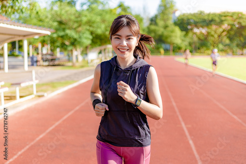Beautiful young Asian woman exercising in the morning at a running track