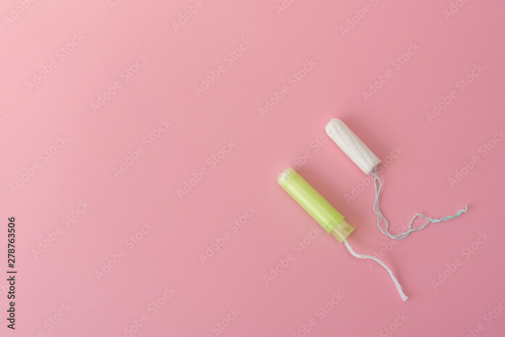 Two cotton tampons with light green applicator and without applicator