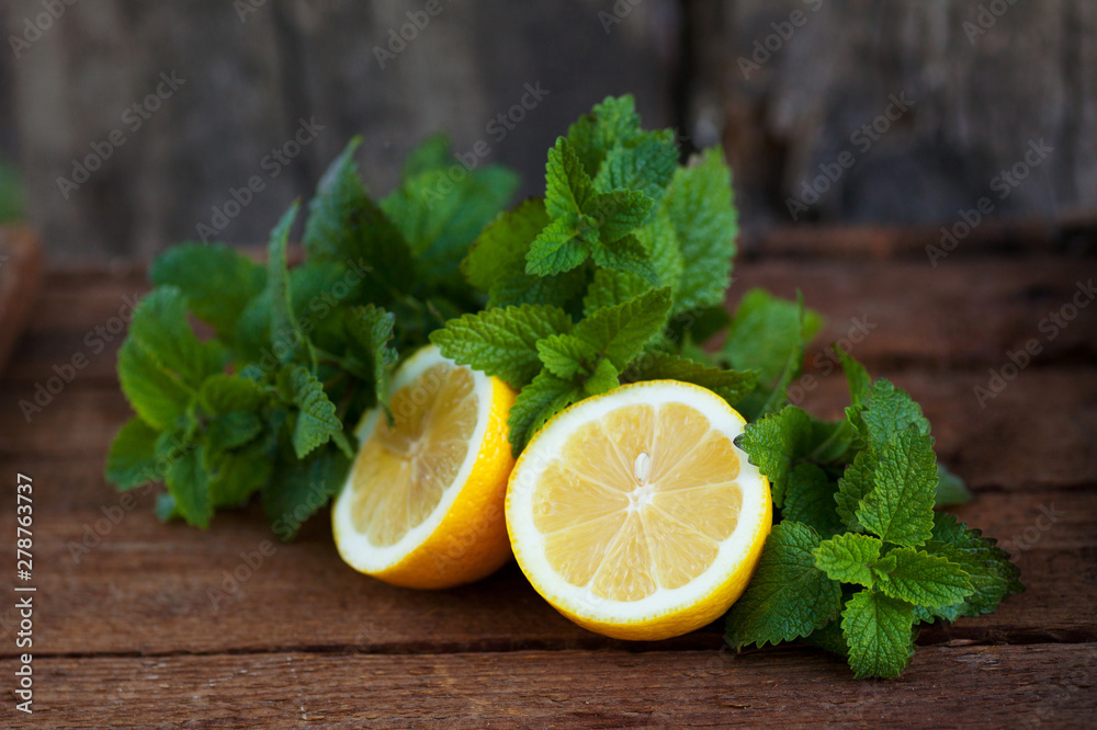 Fresh lemon with mint leaves on old wooden background Fresh lemon with mint leaves on old wooden background