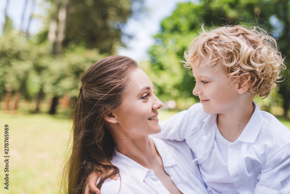 beautiful happy mother looking at adorable son in park beautiful happy mother looking at adorable son in park