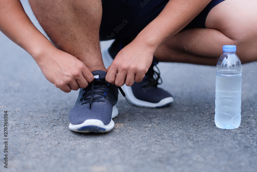 Man tighten shoelaces for running in healthy lifestyle 