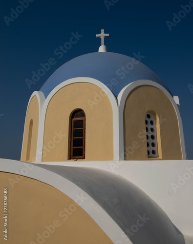 Whitewashed yellow church and blue dome in the village of Vothanos on the idyllic island of Santorini photo