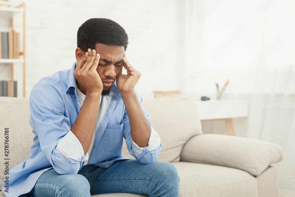 African-american man suffering from headache at home