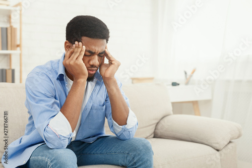 African-american man suffering from headache at home © Prostock-studio