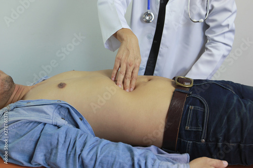 Fototapeta Naklejka Na Ścianę i Meble -  Closeup of Doctor examines or treatment the man abdomen on white background, Health concept