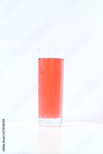 Glass of red liquid on white background, São Paulo, Brazil photo