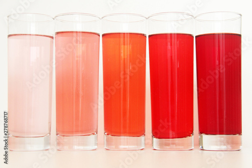 Five glasses of red liquid on white background, São Paulo, Brazil photo