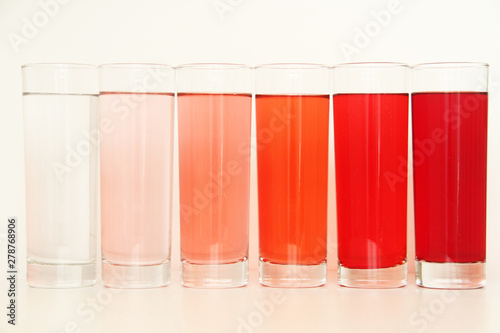 Five glasses of red liquid on white background, São Paulo, Brazil photo