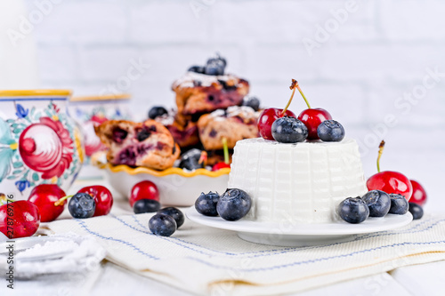 Homemade pastries with ricotta and berries. cheese cake for breakfast. Italian food on a white background. Healthy baking and proper nutrition. Copy space. © Marina