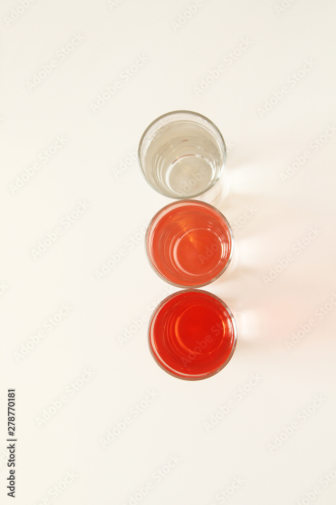 Three glasses of red and transparent liquid on white background, São Paulo, Brazil Three glasses of red and transparent liquid on white background, São Paulo, Brazil