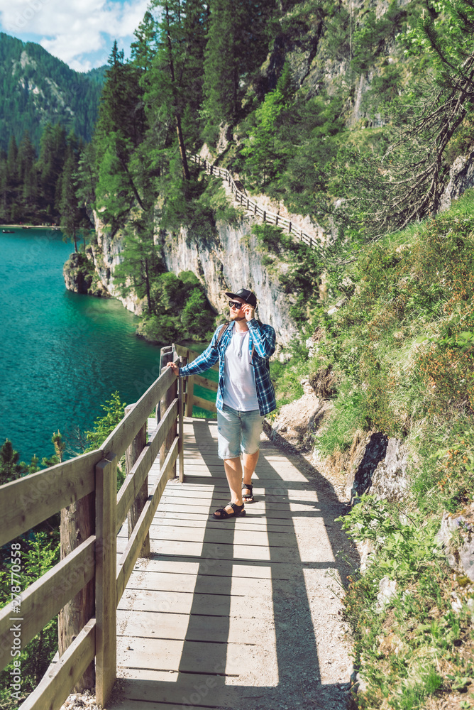 man walking by hiking trail around braies lake in italy dolomites mountains man walking by hiking trail around braies lake in italy dolomites mountains