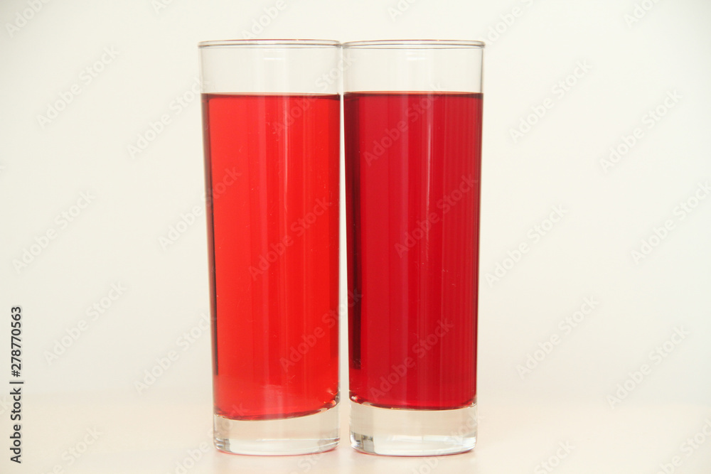 Two glasses of red and transparent liquid on white background, São Paulo, Brazil Two glasses of red and transparent liquid on white background, São Paulo, Brazil