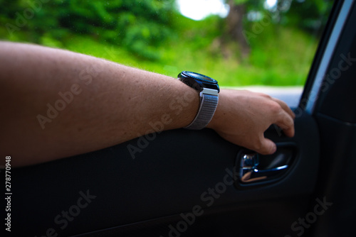 car travel concept man hand on car cart at backseats with watch on wrist