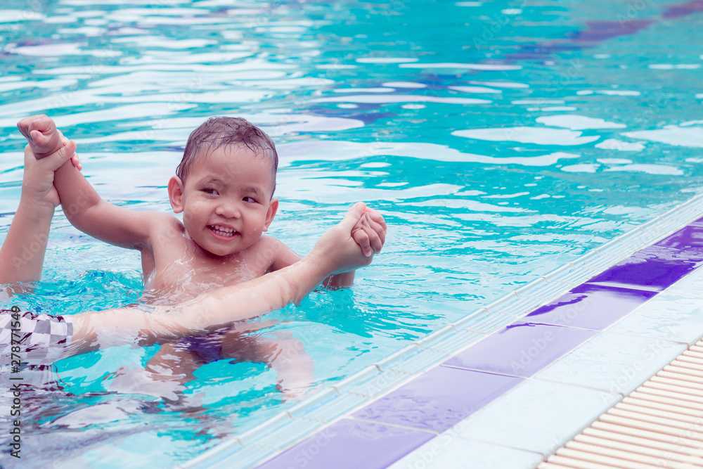 asian mother and baby in swimming pool.  little baby having fun in a swimming pool at thailand