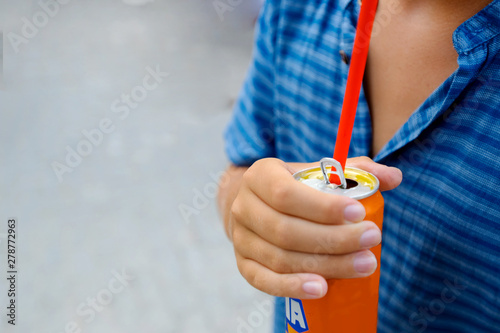 Tanned teenage boy drinks soft carbonated drink. Close-up