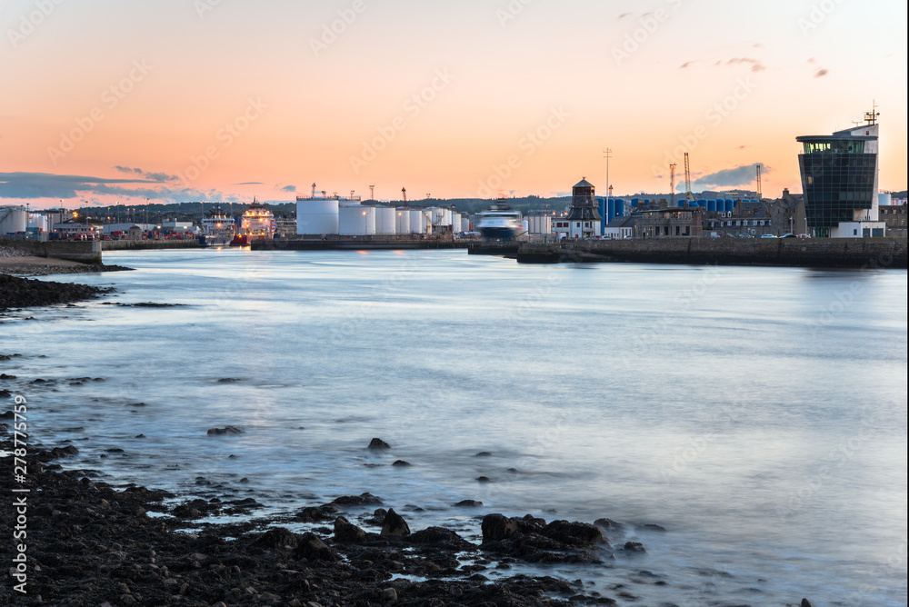 Industrial harbour with huge fuel tanks on piers at dusk