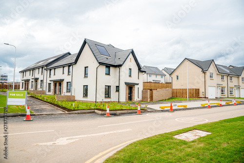 Fototapeta Naklejka Na Ścianę i Meble -  Newly built energy efficient houses with solar panels on the roof  on sale in a housing estate in UK