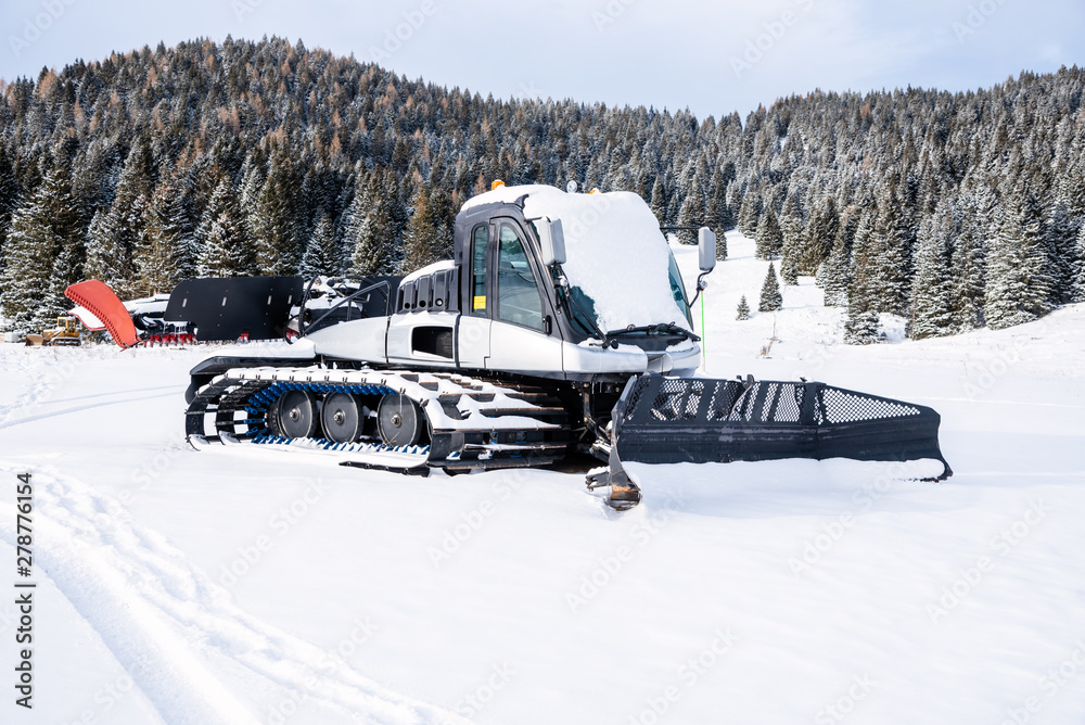 Snowcat covered in fresh in a mountain resort on a winter day Snowcat covered in fresh in a mountain resort on a winter day