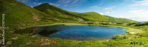 Lake Nesamovite in the Carpathians in the summer sunny day. Alpine lake in the mountains in the summer season. Amazing mountain landscape in mountain valley. Montenegrin Range in the Carpathians.