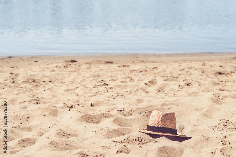 Beautiful sandy beach and straw hat. Summer and travel concept
