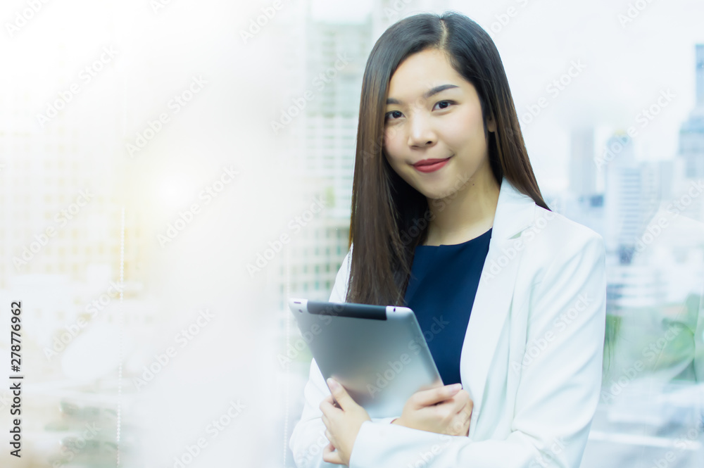 A beautiful business woman with white suit using tablet for working A beautiful business woman with white suit using tablet for working