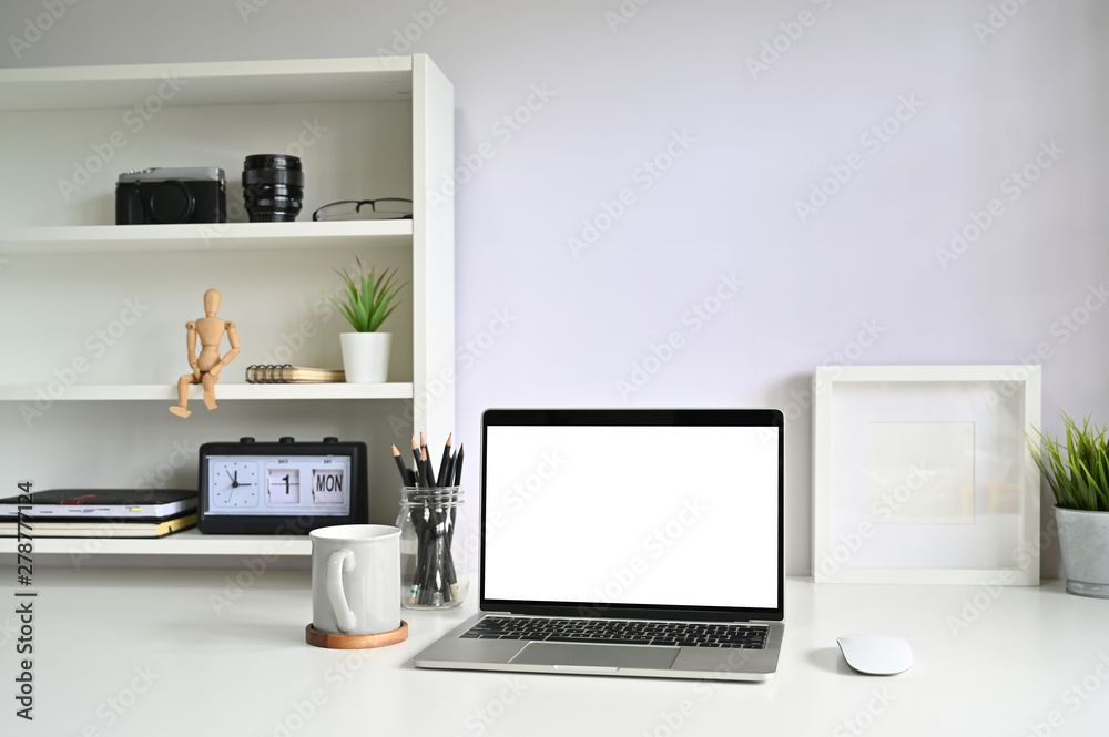 Mockup laptop computer and coffee mug on workspace.