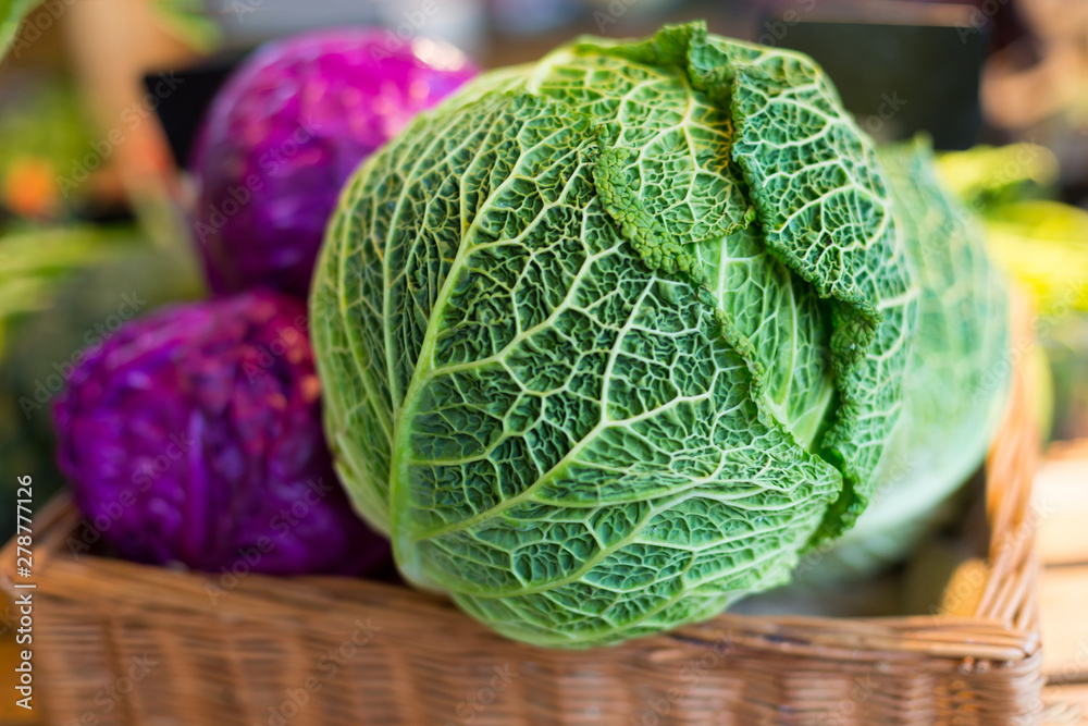 Fototapeta premium Savoy cabbage super food close up, on farmer market, against the background purple cabbage