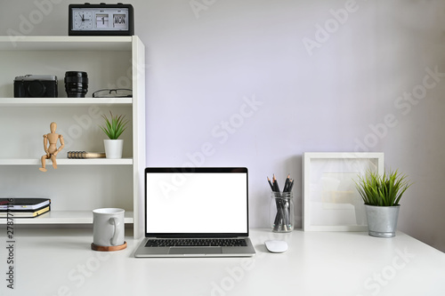 Mockup laptop computer and coffee mug on workspace. © Prathankarnpap