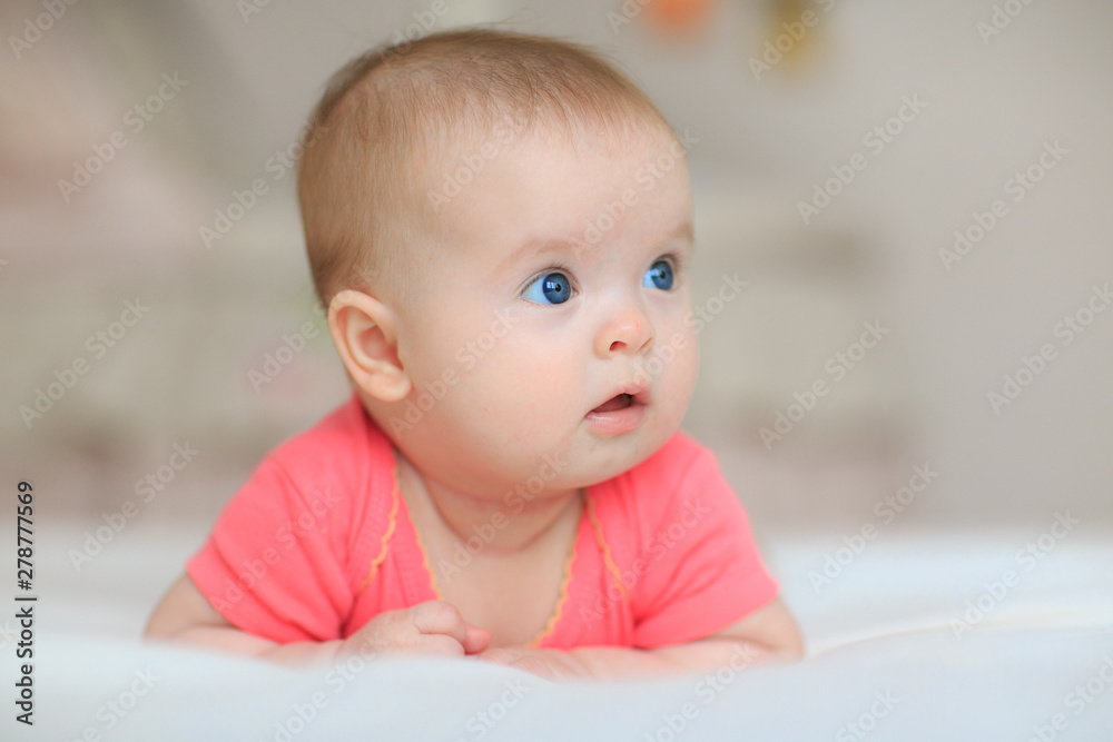 A cute little baby is looking into the camera. little baby with blue eyes A cute little baby is looking into the camera. little baby with blue eyes