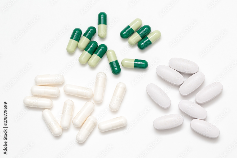 Green and white capsules pills  closeup isolated on white background