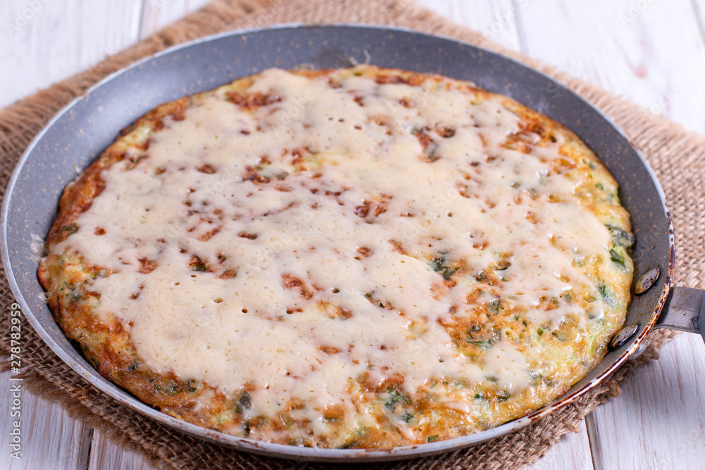 Frying pan with tasty thin pancakes with greens