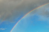 Beautiful rainbow in the blue sky shimmers bright colors