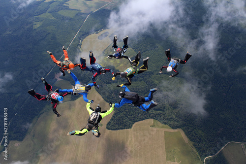 Skydiving. A group of skydivers is in the sky.