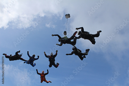 Skydiving. A group of skydivers is in the sky.