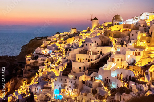 Beautiful view of fabulous picturesque village of Oia with traditional white houses and windmills in Santorini island at night, Greece